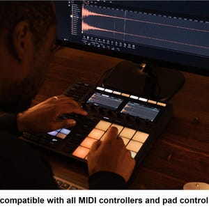 K&ouml;nnte beinhalten: Ein schwarzer MIDI-Controller mit beleuchteten Pads und zwei kleinen Bildschirmen wird verwendet. Der Controller befindet sich auf einer Holzoberfl&auml;che, mit einem Computermonitor, der Audio-Wellenformen im Hintergrund anzeigt. Der Text unten lautet "Fully compatible with all MIDI controllers and pad controllers."