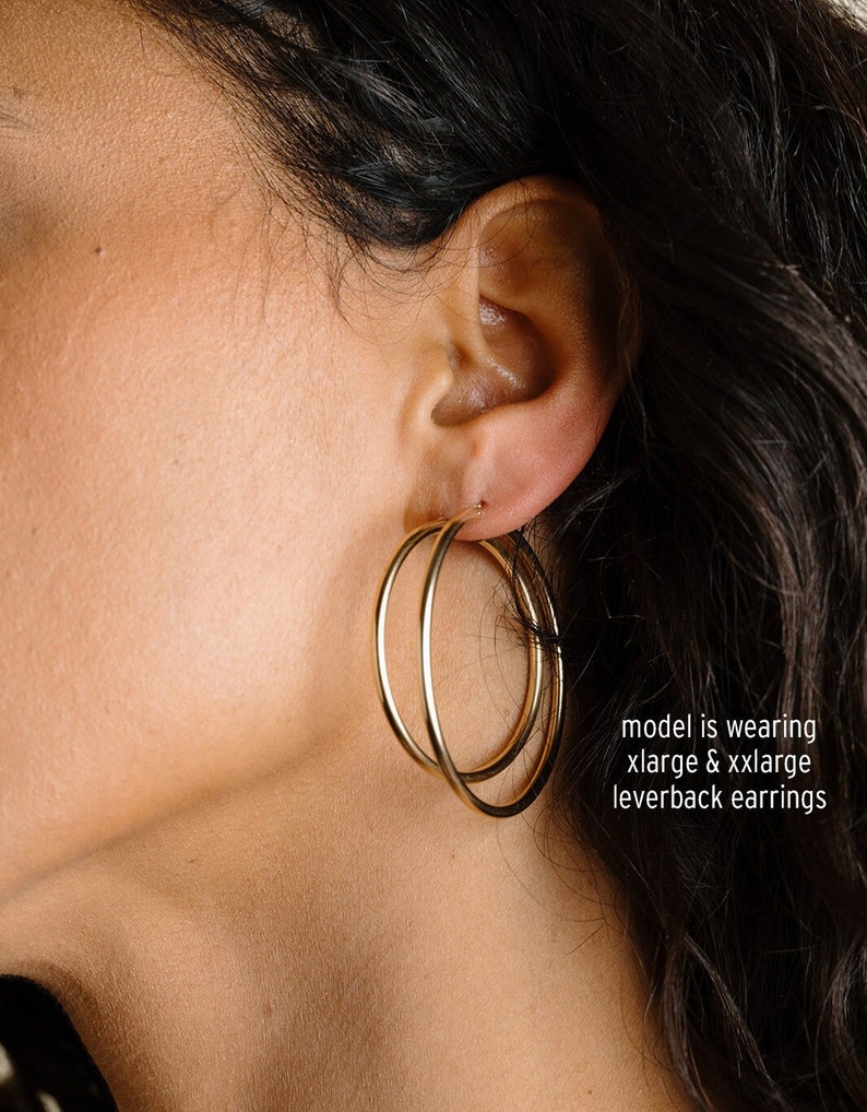 Peut inclure: Gros plan sur une oreille portant une paire de cr&eacute;oles dor&eacute;es &agrave; fermoir &agrave; levier. Le mod&egrave;le porte une paire de cr&eacute;oles de grande taille et une paire de cr&eacute;oles extra-larges. "model is wearing xlarge & xxlarge leverback earrings"