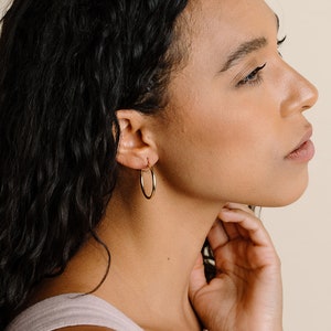 Peut inclure: Une mod&egrave;le porte de grandes boucles d'oreilles cr&eacute;oles en or. Les boucles d'oreilles sont simples et &eacute;l&eacute;gantes, et seraient un excellent ajout &agrave; toute collection de bijoux.
