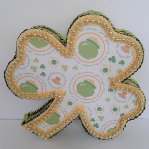 May include: A green shamrock-shaped card with gold glitter trim and a pot of gold at the end of the rainbow design. The card says "Happy St. Patrick's Day" and "Leprechauns leprechauns leprechauns".