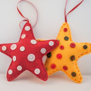 May include: Two felt star ornaments, one red with white buttons and one yellow with red and green buttons.