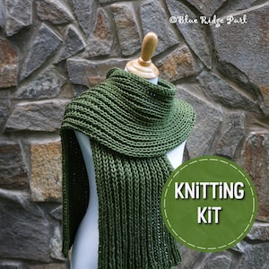 May include: A green knitted scarf with a ribbed texture. The scarf is displayed on a mannequin against a stone wall. The text "Knitting Kit" is visible in a green circle.