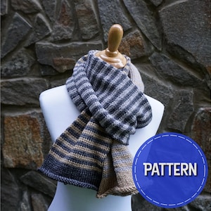 May include: A striped knit scarf in shades of gray, brown, and beige. The scarf is displayed on a white mannequin against a stone wall background. The word "PATTERN" is written in white text on a blue circle.