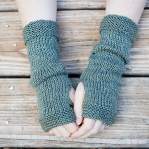 slouchy knitted gloves scrunched and resting close to wrist made from soft wool yarn with a thumb opening and all fingers to be free for typing