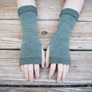 wool arm warmers hand knit is a beautiful selection of green yarns covers about 10 inches from fingers to mid arm with a thumbhole smooth knit fabric and textured border