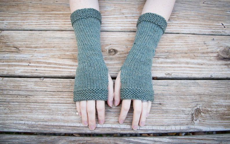 wool arm warmers hand knit is a beautiful selection of green yarns covers about 10 inches from fingers to mid arm with a thumbhole smooth knit fabric and textured border