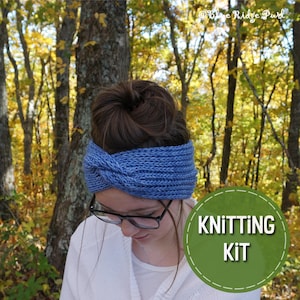 May include: A blue knitted headband with a twist design. The headband is being worn by a person with brown hair. The image has the text "Knitting Kit" on a green circle.
