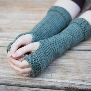 blue green knit wool arm warmers with thumbhole snug fitting and covers to the middle of  forearm