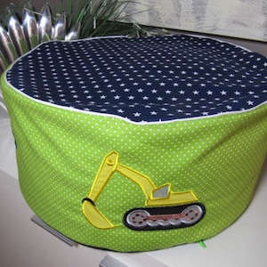 Könnte beinhalten: Ein grüner und blauer Stoffaufbewahrungskorb mit weißem Punktmuster und einem gestickten gelben Baggerdesign. Der Korb hat einen weißen Rand um den oberen Rand.