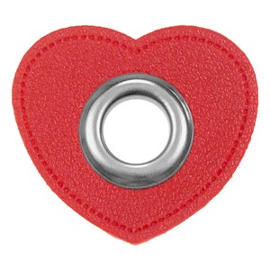 May include: Red heart-shaped leather patch with a silver metal eyelet in the centre.