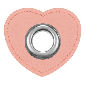 Könnte beinhalten: Ein rosafarbenes, herzförmiges Lederstück mit einem silbernen Metallösen in der Mitte.