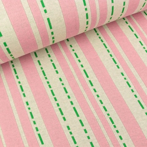 May include: Pink and white striped fabric with green dashed lines. The fabric has a woven texture.