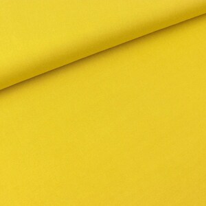 Peut inclure: Un échantillon de tissu jaune uni. Le tissu a une texture lisse et uniforme.