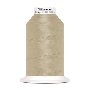 Könnte beinhalten: Eine Spule Gütermann Bulky-Lock 80 Garn in hellbeige. Die Spule ist 1000 Meter lang.