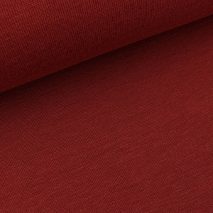 Può includere: Primo piano di un rotolo di tessuto rosso. Il tessuto ha una superficie strutturata e una leggera lucentezza. Il colore è un rosso intenso e ricco, con sottili variazioni di tono. Il tessuto è a trama fitta e sembra di alta qualità.