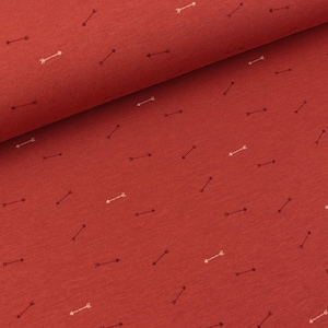 May include: Red fabric with a repeating pattern of white and brown arrows.