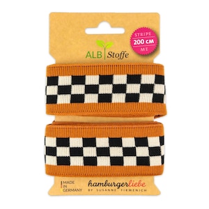 Könnte beinhalten: Zwei Rollen orange-schwarzes kariertes Gummiband, jeweils 200 cm lang. Das Band ist mit "hamburgerliebe by susanne firmenich" beschriftet.
