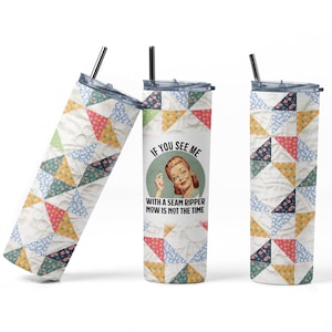 May include: A white tumbler with a patchwork design and the text "If you see me with a seam ripper now is not the time". The tumbler features a retro-style illustration of a woman holding a seam ripper.