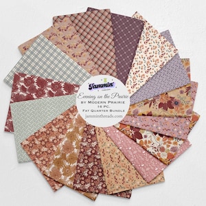 May include: A circular arrangement of sixteen fat quarter fabric pieces. The fabrics feature floral, plaid, and geometric patterns in shades of burgundy, tan, and blue. The center has a white circle with text that reads "Evening on the Prairie" and "Fat Quarter Bundle".