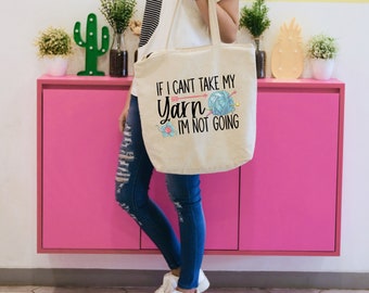 May include: A white canvas tote bag with the text "If I can't take my yarn I'm not going" and a colorful illustration of yarn and knitting needles.