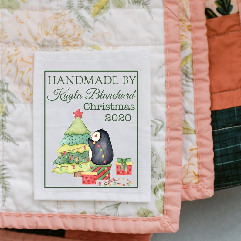 Christmas quilt label handmade by personalized name Christmas personalized date, christmas tree with penguin hanging up lights, cotton sew on or polyester sew on quilt label. by Jammin' Threads