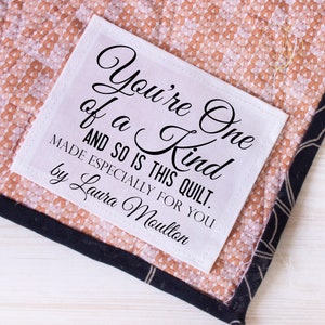 May include: White fabric label with black text that reads "You're One of a Kind and so is this quilt. Made especially for you by Laura Moulton."