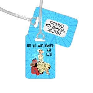 May include: Blue luggage tag with a pop art illustration of a woman sitting on suitcases. The text "Not all who wander are lost" is printed on the tag. The back of the tag has contact information for Mireya Yoder.