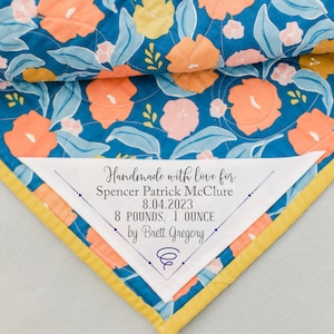 Corner Quilt Labels personalized with baby&#39;s birth information on cotton fabric in sew on form and measuring approximately 5 x 5&quot;