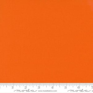 May include: Bright orange fabric with a textured surface. A ruler is at the bottom of the image, marked in inches. The fabric is a solid color, suitable for various sewing and crafting projects.