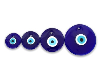 Puede incluir: Cuatro amuletos de ojo turco azules de diferentes tamaños con centros blancos y negros. Los amuletos son redondos y tienen un agujero en la parte superior para colgar.