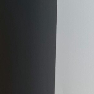 May include: A close-up of a section of a calendar or a similar item. The image is divided into two vertical sections: a black section on the left and a white section on the right. The number 11 is in white on the black section, and the number 12 is in black on the white section.