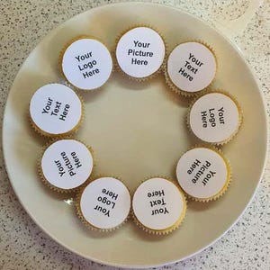 May include: Eight white cupcake liners with black text on top. The text on the cupcake liners reads: "Your Logo Here", "Your Text Here", "Your Picture Here", and "Your Text Here".