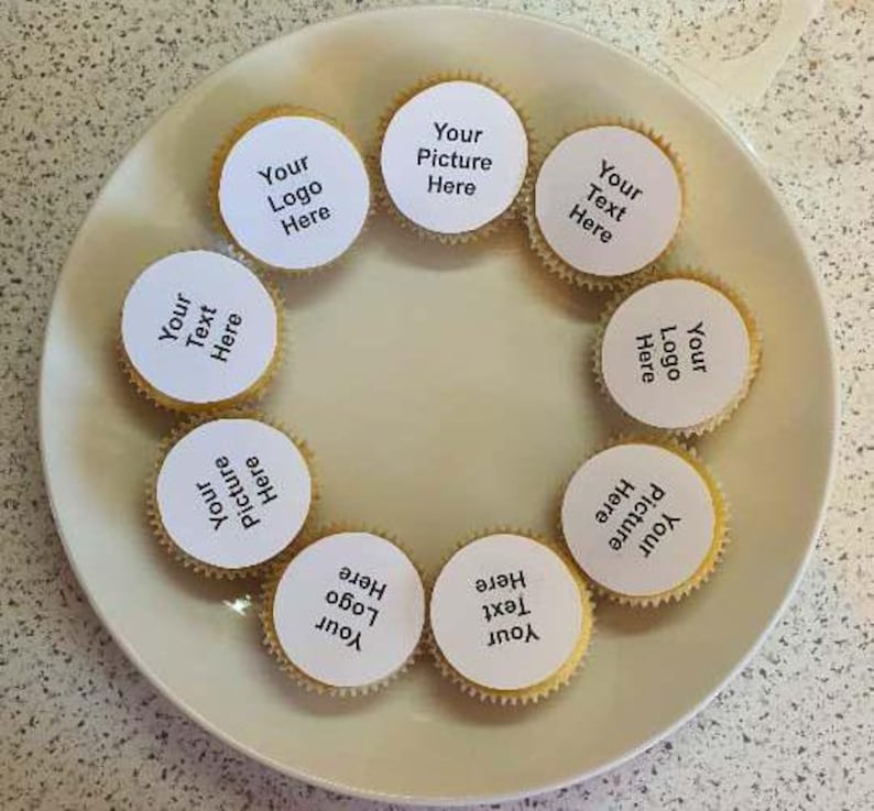 May include: Eight white cupcake liners with black text on top. The text on the cupcake liners reads: "Your Logo Here", "Your Text Here", "Your Picture Here", and "Your Text Here".