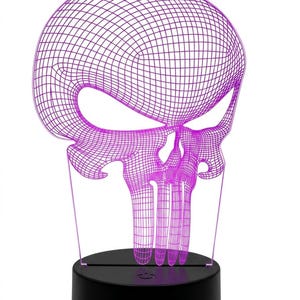 May include: A purple wireframe skull-shaped LED lamp. The skull design is illuminated with a bright purple light and sits on a black circular base. The lamp is a decorative item.