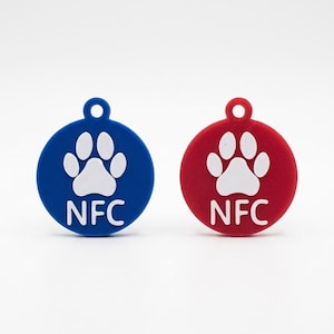 Peut inclure: Deux médailles rondes pour animaux de compagnie, une bleue et une rouge, avec une empreinte de patte blanche et les lettres "NFC". Les médailles ont un petit trou en haut pour l'attache.