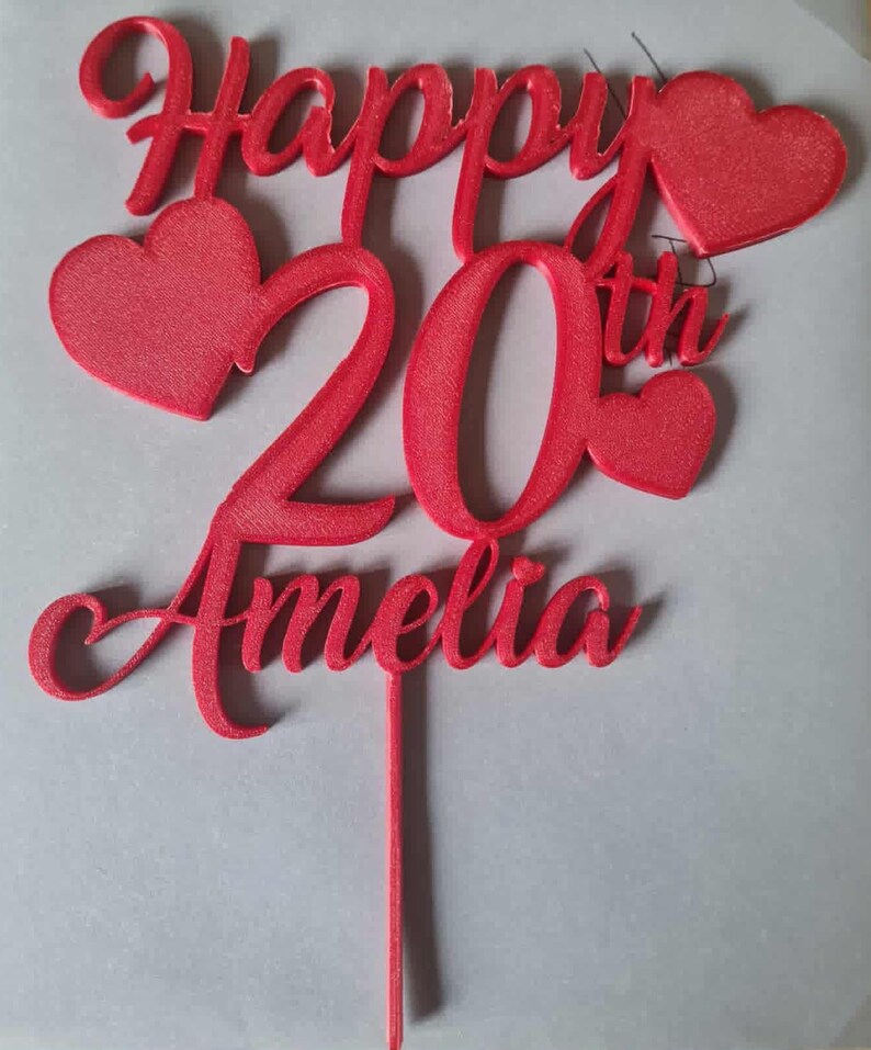 以下が含まれることがあります： 「Happy 20th Amelia」の文字とハートの形が特徴的な赤いケーキトッパー。 スクリプトフォントでデザインされ、しっかりとした素材で作られています。 ケーキに挿入して使用するように設計されています。