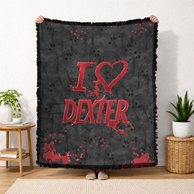May include: Black throw blanket with the text "I ❤️ DEXTER" in red. The blanket has a distressed, textured background with red splatter details and a fringed edge. The blanket is being held up by a person.