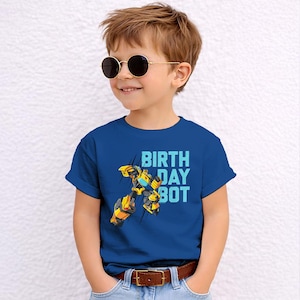 May include: A blue t-shirt with the text "BIRTH DAY BOT" and a yellow and black robot graphic. The shirt is worn by a child wearing sunglasses and jeans.