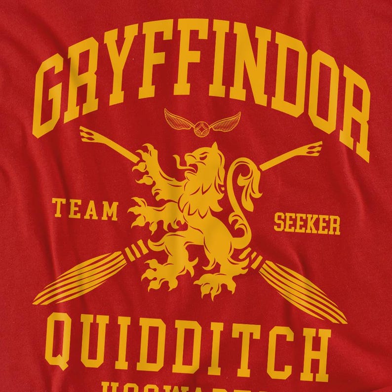 May include: Red t-shirt with a yellow Gryffindor Quidditch design. The design includes the word "Gryffindor" at the top, a lion emblem, the words "Team Seeker", and the word "Quidditch" at the bottom. The shirt is made of a soft material.