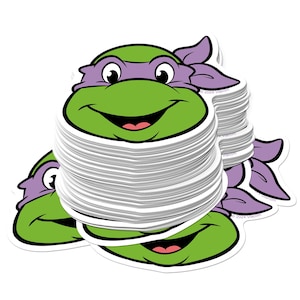 May include: A stack of stickers featuring a cartoon turtle head with a green face, purple mask, and a smiling mouth. The stickers are white with a die-cut shape and a glossy finish. The stickers are from the Teenage Mutant Ninja Turtles.