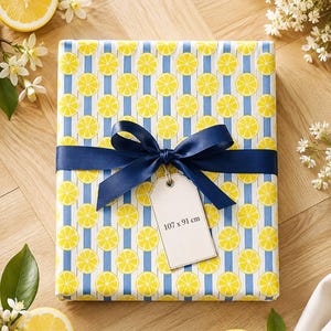 Peut inclure: Un cadeau rectangulaire emballé dans du papier à motif de tranches de citron jaunes sur des rayures verticales bleu clair et blanches. Un ruban de satin bleu foncé est noué en boucle autour du centre, retenant une étiquette blanche 107 x 91 cm.