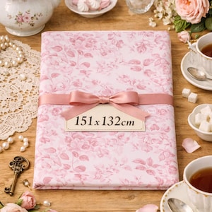 Peut inclure: Un tissu rose à motifs floraux, mesurant 151 x 132 cm, est noué avec un ruban et un nœud assortis. La scène comprend une théière, des tasses à thé, des roses et des sucreries, créant une esthétique vintage et romantique.