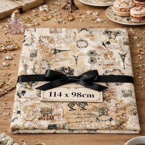 Peut inclure: Un paquet rectangulaire enveloppé dans du papier au design parisien vintage, noué avec un ruban noir. Le papier présente des illustrations de vélos, de la Tour Eiffel et des écritures. Le paquet mesure 114 x 98cm.