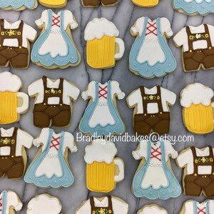May include: A collection of 20 decorated sugar cookies featuring various designs, including beer steins, dirndls, and lederhosen. The cookies are decorated with white, blue, brown, and yellow icing. The text "Bradleydavidbakes@etsy.com" is visible in the image.