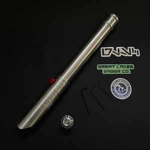 May include: A silver lightsaber with a red button, a silver pommel, and three small black hex keys. The lightsaber is next to stickers that say "DNNH" and "Great Lakes Saber Co."