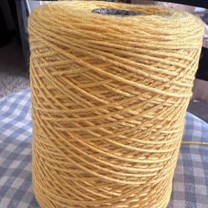 May include: A large spool of yellow yarn.