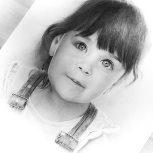 Puede incluir: Un dibujo a l&aacute;piz en blanco y negro de una ni&ntilde;a joven con el pelo largo y oscuro y flequillo. Lleva una camisa blanca con una correa marr&oacute;n. La ni&ntilde;a mira directamente al espectador con una expresi&oacute;n seria.