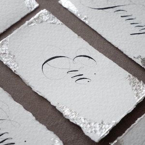 Tarjeta de nombre de boda escrita a mano en papel texturizado, tarjetas de lugar de caligrafía con hoja de plata, tarjetas de nombre escritas a mano, tarjeta de lugar con bordes rugosos