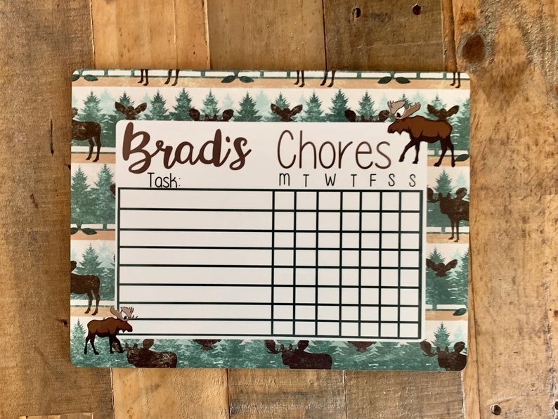 K&ouml;nnte beinhalten: Ein wei&szlig;er Trockenl&ouml;sch-Chore-Chart mit einem Elch- und Waldmotiv. Der Chart hat Platz f&uuml;r einen Namen, "Brad's Chores", und einen Bereich f&uuml;r Aufgaben mit den Wochentagen, die oben aufgelistet sind.