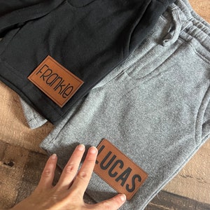 Shorts för pojkars namn: Svarta shorts med läderlappar för småbarn och ungdom